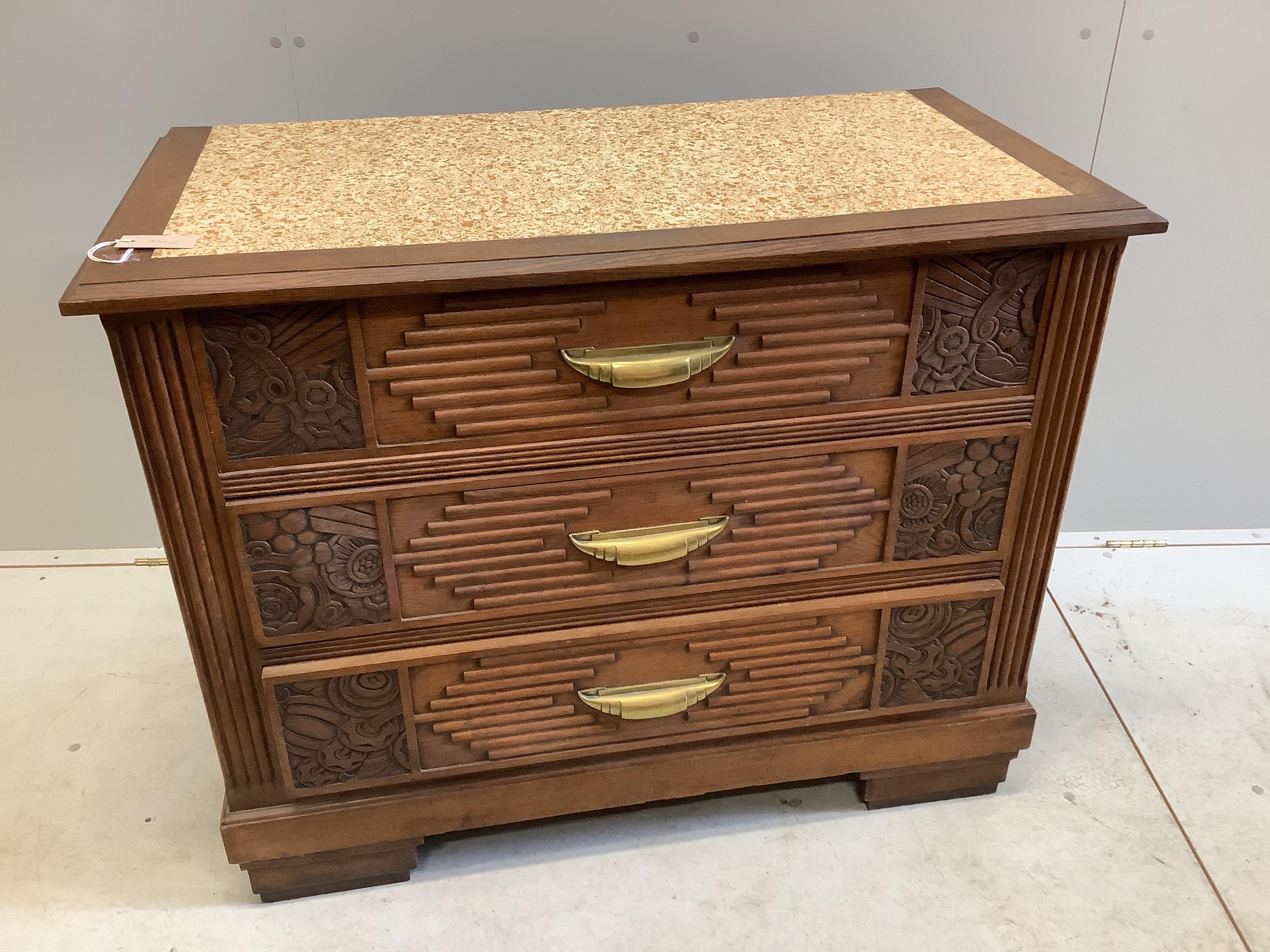 A French Art Deco carved oak three drawer chest with simulated marble top, width 105cm, depth 63cm, height 84cm
